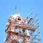 Laborers busy in renovation of clock tower during maintenance work to preserve the building in the city.