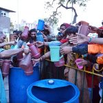 A volunteer distributes drink among people before iftar at Cantt Station during holy fasting month of Ramazan