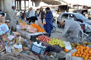 A street vendor serves pakoras and samosas to customers for iftar