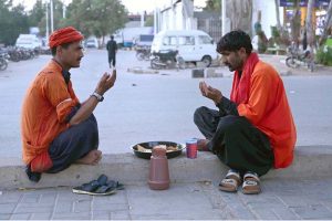 A volunteer distributes drink among people before iftar at Cantt Station during holy fasting month of Ramazan