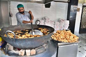 Vendors busy prepare traditional food items, including Samosas in the shop during the holy fasting month of Ramazan.