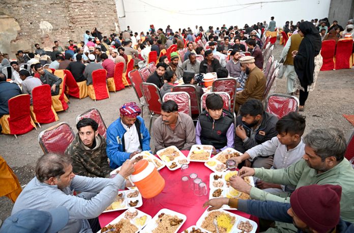 A large number of people having Iftar to break their fast at Chowk Allama Iqbal