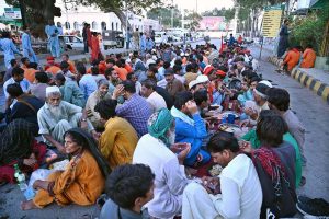 A volunteer distributes drink among people before iftar at Cantt Station during holy fasting month of Ramazan