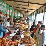 People purchase different items in preparation for the first iftar from a stall at Sahulat Bazar