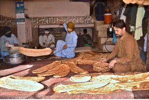 A roti maker displays ‘Afghani Naan’ to attract the customers at his tandoor ahead of Iftar during holy month of Ramazan.