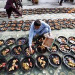 A man prepares Iftar meals for underprivileged people under Qayyumabad flyover