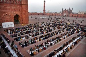 A large number of people wait for the Maghrib Azan before breaking their fast with iftar meals during the holy fasting month of Ramazan at the historical Badshahi Mosque in the provincial capital