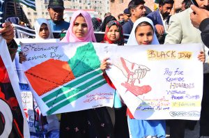 Students holding a play cards depicting solidarity with the people of Kashmir during a rally on Kashmir Solidarity Day at Thandi Sarak.