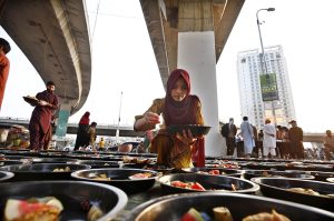 A man prepares Iftar meals for underprivileged people under Qayyumabad flyover