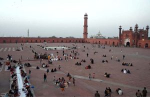 A large number of people wait for the Maghrib Azan before breaking their fast with iftar meals during the holy fasting month of Ramazan at the historical Badshahi Mosque in the provincial capital
