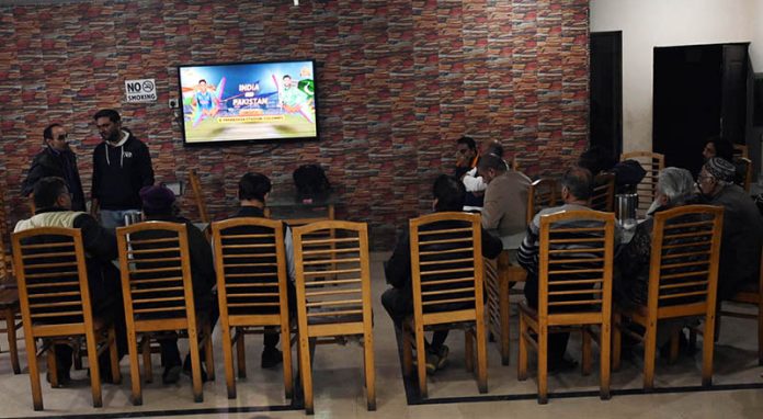 People watch and enjoy the T20 cricket match between Pakistan and India on TV screen in the Provincial Capital