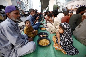 Underprivileged people taking free Iftar meals under Qayyumabad flyover