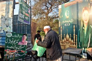 A man carries flour bags after shopping at a Ramazan Sasta Bazaar