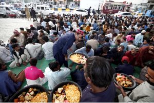 Underprivileged people taking free Iftar meals under Qayyumabad flyover