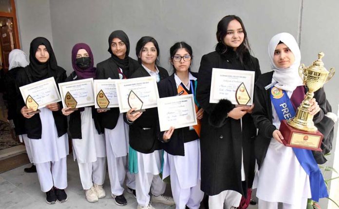 Winner students of the flower arrangement and card making competitions pose for a group photo with their certificates and trophy during an intercollegiate ceremony held at Model College for Girls, I-14/3