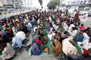 Underprivileged people taking free Iftar meals under Qayyumabad flyover