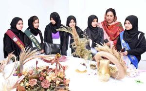 Winner students of the flower arrangement and card making competitions pose for a group photo with their certificates and trophy during an intercollegiate ceremony held at Model College for Girls, I-14/3