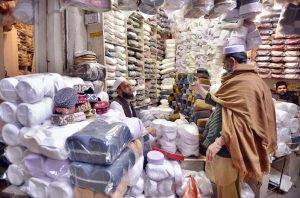 A customer selects and purchases prayer caps at Chowk Yadgar ahead of the holy month of Ramadan.