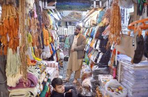 A customer selects and purchases prayer caps at Chowk Yadgar ahead of the holy month of Ramadan.