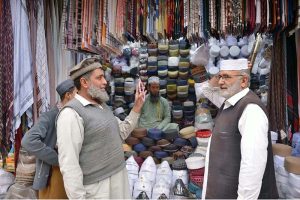 A customer selects and purchases prayer caps at Chowk Yadgar ahead of the holy month of Ramadan.