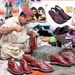 A cobbler preparing traditional shoes (man sandles) on order of people ahead of Eid-ul Fitr