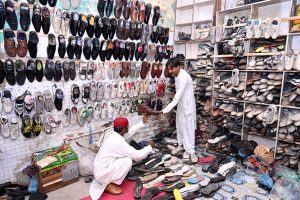 A cobbler preparing traditional shoes (man sandles) on order of people ahead of Eid-ul Fitr