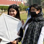 Students poses with a kite during the Basant Bahar Festival at Chandka Medical College