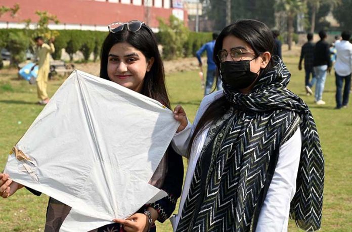 Students poses with a kite during the Basant Bahar Festival at Chandka Medical College