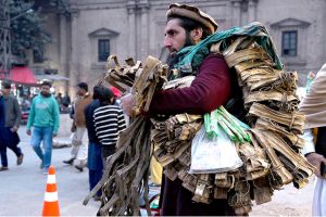 Ladies selecting colorful bedsheets, curtains, and other fabrics from a vendor near Delhi Gate