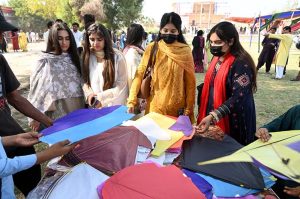 Students poses with a kite during the Basant Bahar Festival at Chandka Medical College