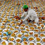 A volunteer prepares and arranging the plates of Iftar food free for the common people to break their fast on the first day of the Islamic holy month of Ramazan, at the Data Darbar shrine in the Provincial Capital