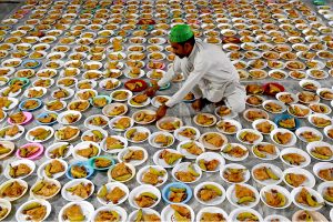 A volunteer prepares and arranging the plates of Iftar food free for the common people to break their fast on the first day of the Islamic holy month of Ramazan, at the Data Darbar shrine in the Provincial Capital