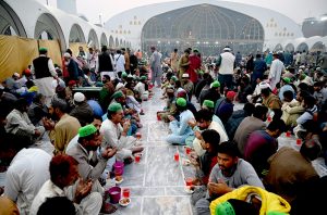 A volunteer prepares and arranging the plates of Iftar food free for the common people to break their fast on the first day of the Islamic holy month of Ramazan, at the Data Darbar shrine in the Provincial Capital