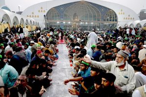 A volunteer prepares and arranging the plates of Iftar food free for the common people to break their fast on the first day of the Islamic holy month of Ramazan, at the Data Darbar shrine in the Provincial Capital