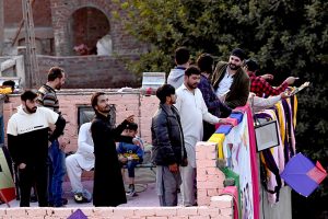 People enjoy flying kites during celebrations of the three-day kite-flying festival “Basant” in the Walled City, marking its return to the provincial capital after two decades under strict administrative control