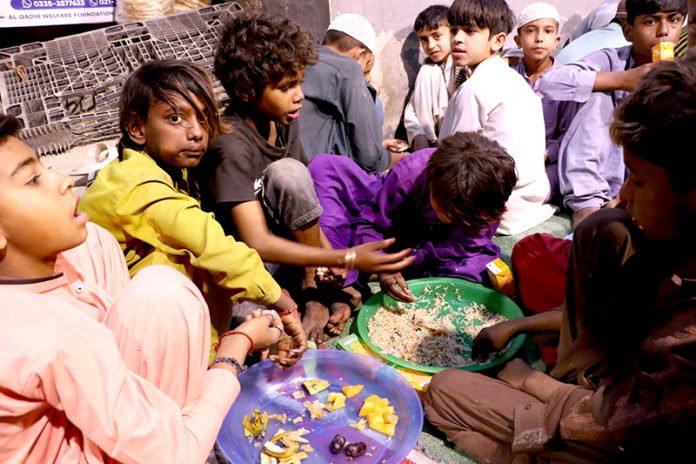 People break their fast during Free Iftar at the roadside in the city on the 2nd day of holy fasting month of Ramazan
