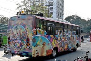 A passenger bus decorated with a Basant poster moves through the city on the first day of the spring festival, celebrated in the provincial capital after twenty years following the lifting of the Basant ban