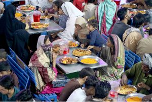A large number of people break their fast during Iftar organized by Chhipa Welfare Free Food Dastarkhawan at the roadside in the city during the holy fasting month of Ramazan