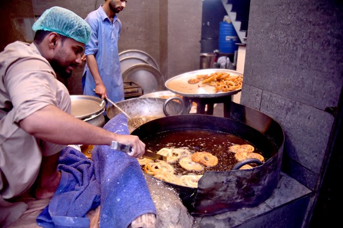 A vendor prepare Jalebi to sell for Iftar at Burns Road