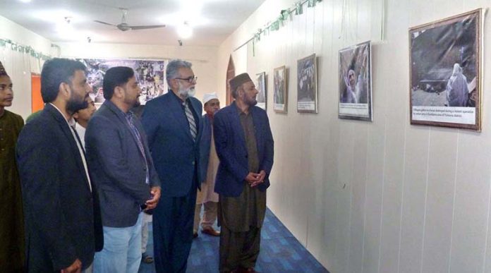 Bahawalpur Arts Council Kashmir Solidarity Day photo exhibition opening ceremony, Member Islamic ideological Council Pakistan Malik Allah Bakhsh, renowned educationist Amir Awan and other are looking at the photos in the photo exhibition