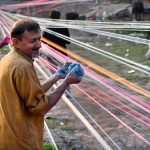 Workers prepare kite-flying string ahead of the upcoming Basant festival in the Provincial Capital