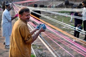 Workers prepare kite-flying string ahead of the upcoming Basant festival in the Provincial Capital