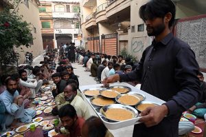 A man distributes iftar meal to fasting people outside his home, embodying the spirit of sharing and compassion during the holy month of Ramazan in the federal capital.