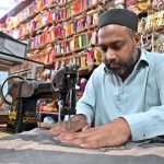 A worker busy in embroidery work on clothes at his workplace for customers as people starts preparation for the upcoming Eidul Fitr celebrations
