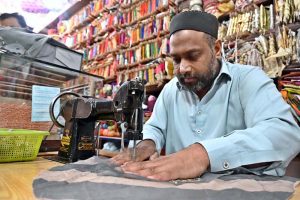 A worker busy in embroidery work on clothes at his workplace for customers as people starts preparation for the upcoming Eidul Fitr celebrations