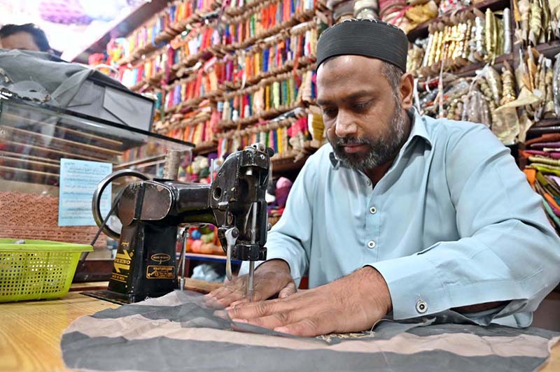 A worker busy in embroidery work on clothes at his workplace for customers as people starts preparation for the upcoming Eidul Fitr celebrations