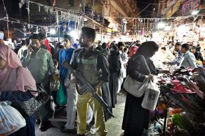 Police official standing alert at Resham Bazaar during the holy month of Ramazan.
