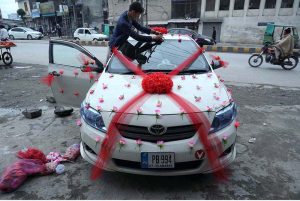 A worker is busy decorating a car for a wedding ceremony at Kabutar Chowk.