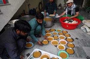 A man distributes iftar meal to fasting people outside his home, embodying the spirit of sharing and compassion during the holy month of Ramazan in the federal capital.