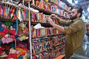 A worker busy in embroidery work on clothes at his workplace for customers as people starts preparation for the upcoming Eidul Fitr celebrations